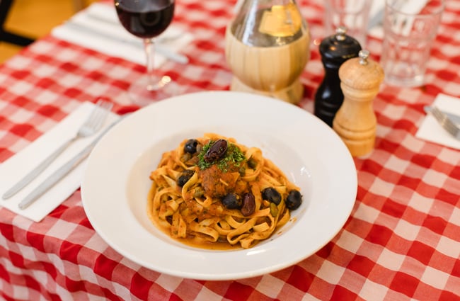 A plate of pasta sits on the red and white tablecloth at Nicolini's.