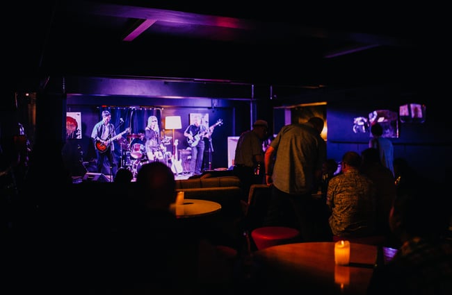 A band plays under purple lights.