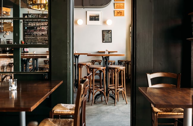 A view of high tables and chairs inside a bar.