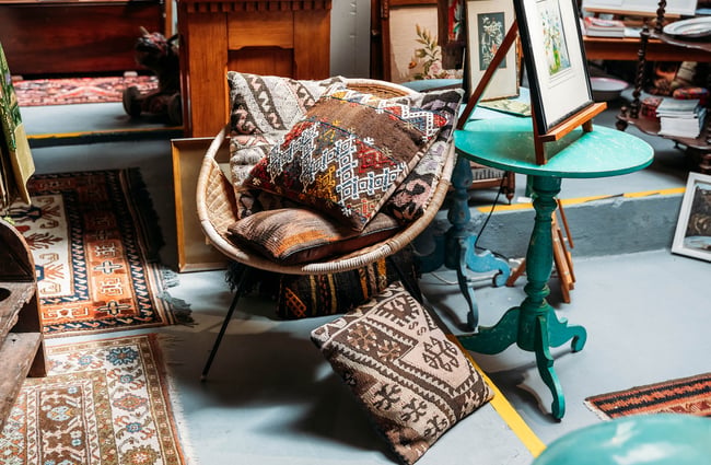 Embroidered cushions on wicker chair at Oásis in Ōamaru