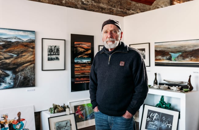 Chris de Jong, one of the gallery owners standing in the gallery in OCTA Gallery in Cromwell Heritage Precinct.