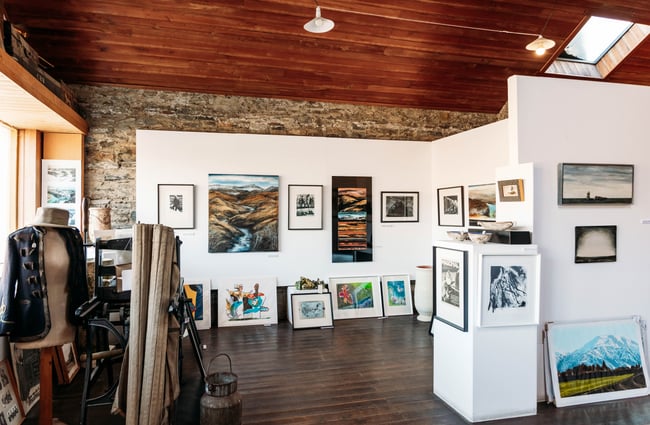 Prints and paintings on the wall in OCTA Gallery in Cromwell Heritage Precinct.