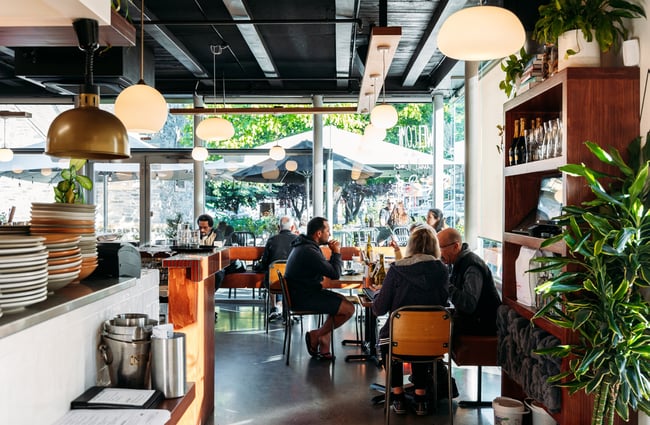 People dining inside a sunny cafe.