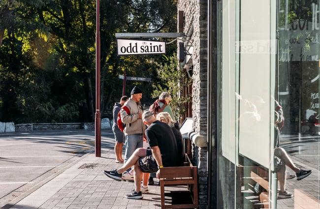 People dining outside a bar on a sunny day.