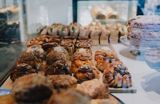 A close up of pastries in a glass cupboard.