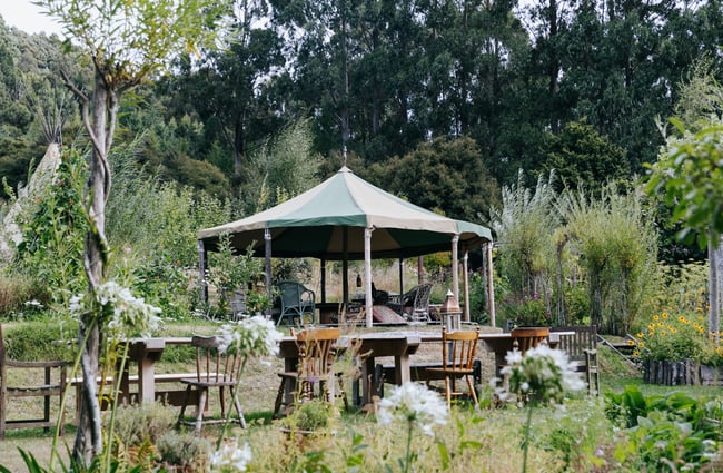 A yurt surrounded by tables and chairs at Okuti Garden in Little River.