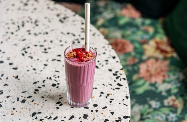 A berry smoothie is placed on a table at Old Courthouse Eatery.