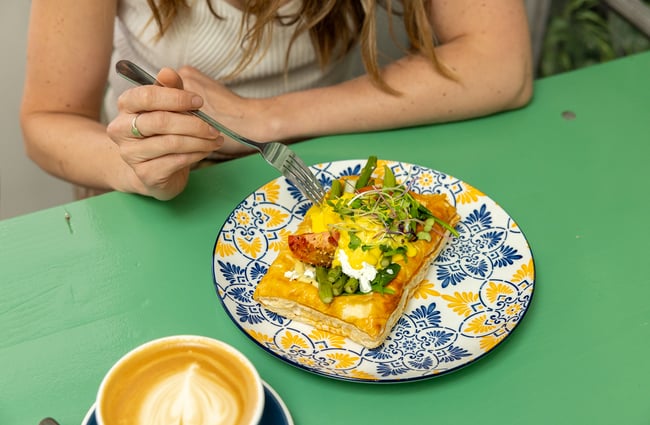 Food on the table and a cup of coffee at the cafe at Old School Collective.