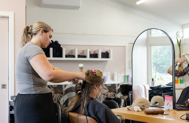 Hairdresser cutting client's hair at The Old School Collective.