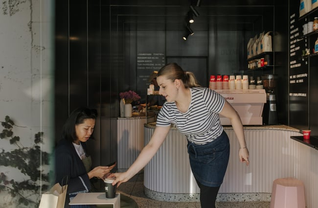 A staff member serving a coffee.