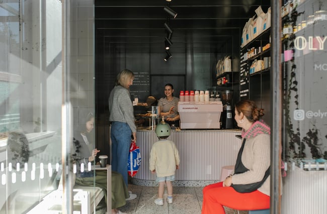 A mother and child ordering at a cafe counter.