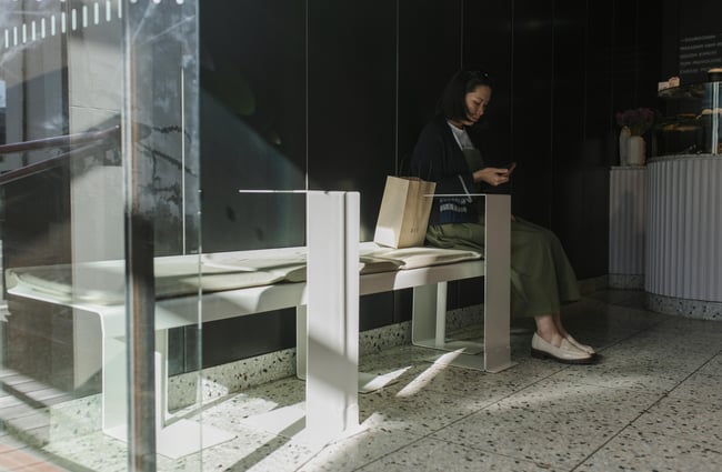 A person on her phone waiting for coffee.