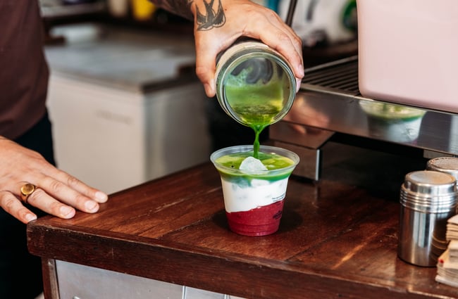 A close up of a strawberry and matcha cold drink.