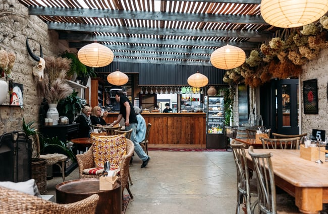 Cosy interior, customers sitting at tables inside at Orchard Garden Cafe.