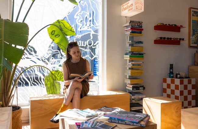 Woman reading magazine at Outdoors Society in Auckland