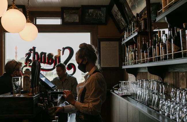 Woman pouring a pint of Guinness at Paddy McNaughton's, Christchurch.