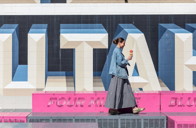 Customer walking past Ōtautahi sign with a gelato cone in their hand from Paleta Gelateria.