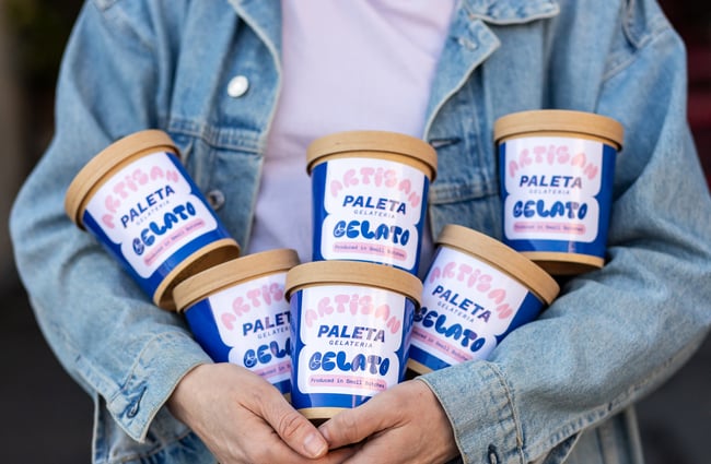 Customer holding a number of take-home tubs of gelato from Paleta Gelateria.