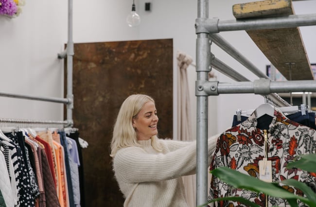 Woman smiling while shopping at Palm Boutique.