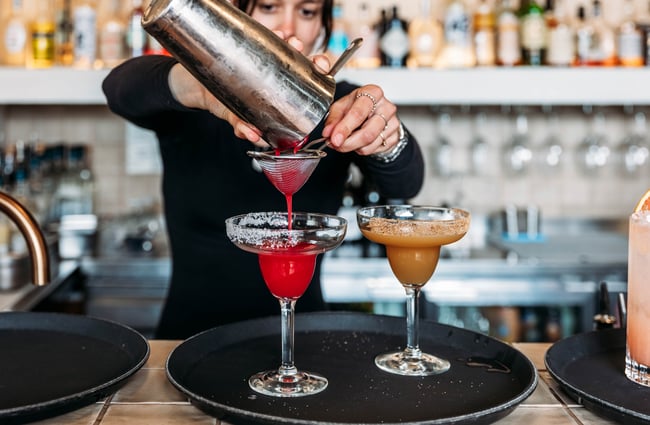 A bartender pours a cocktail at Paloma.