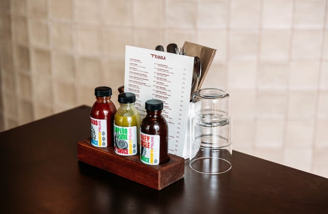 Bottles of hot sauce on the table at Paloma.