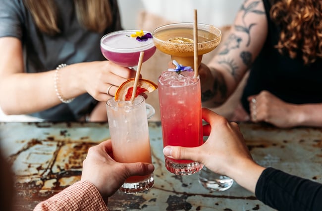Close up of four cocktails in customers' hands at Paloma.