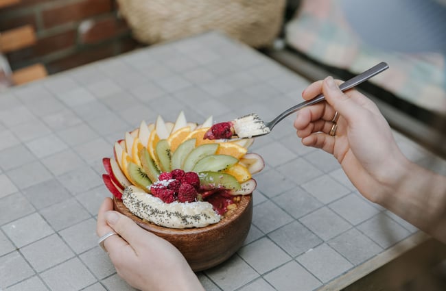 Someone about to eat smoothie bowl with fresh fruit at Park Ranger in Christchurch.