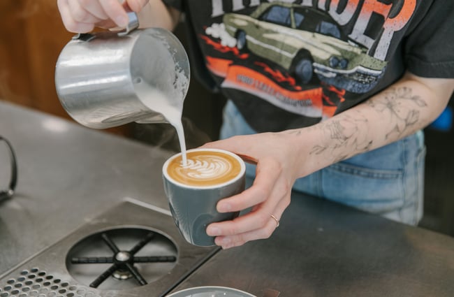 Person pouring flat white at Park Ranger in Christchurch.