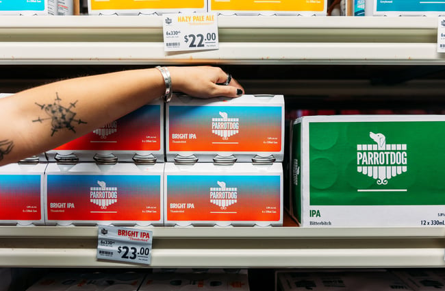 Someone reaching for a six-pack box of ParrotDog beers off the shelf