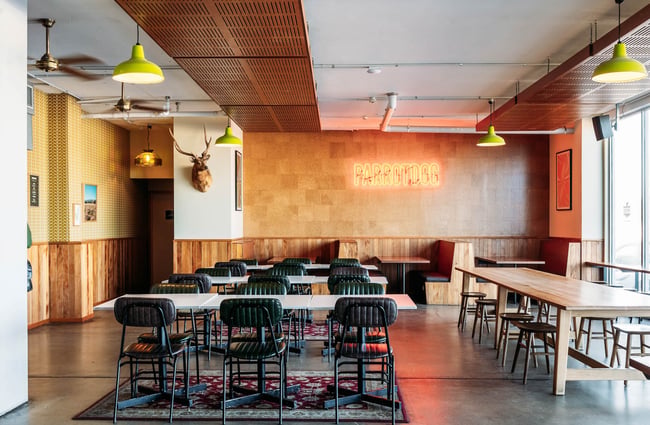 Neon red ParrotDog sign above wooden booths at ParrotDog brewery