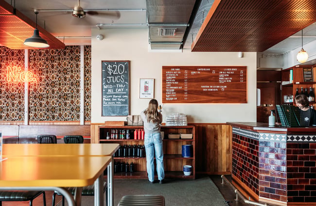 ParrotDog beer menu above dark tiled bar counter