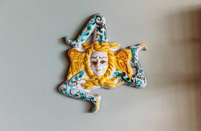 A close up of a work of art on a wall.