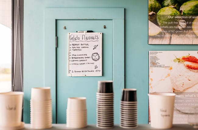 A close up of a gelato menu on a wall.