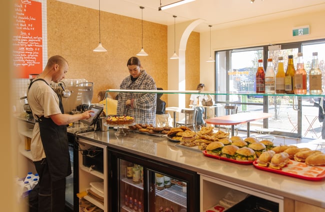 Customer ordering at the counter with food in the the cabinet at Peaches.