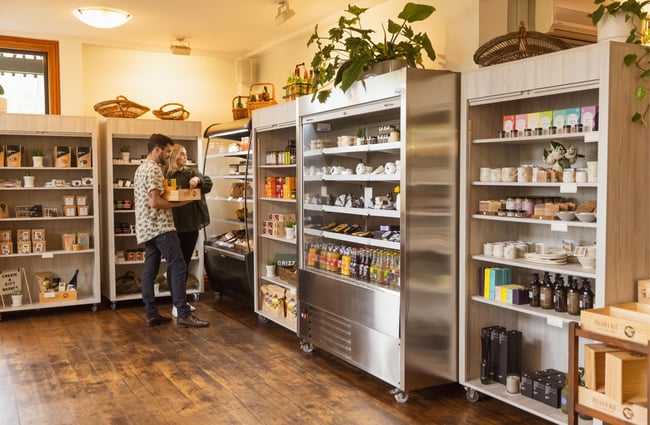 A man and women selecting deli item from the fridges at Pegasus Bay.