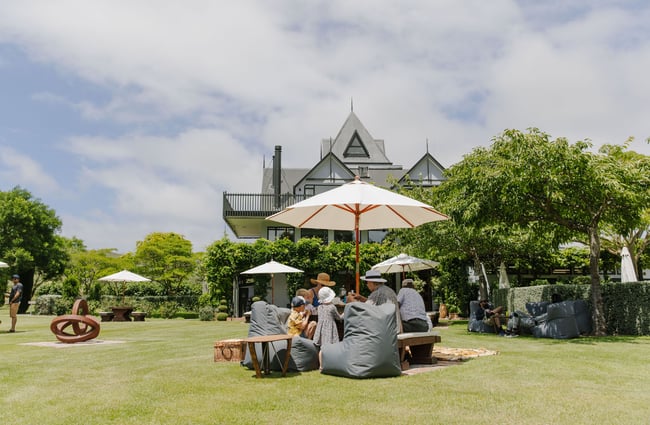 Table of people enjoying the grounds and wine at Pegasus Bay.