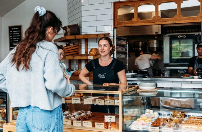 Staff member behind the counter and a customer ordering at Pembroke Pâtisserie,