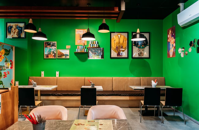 Booth seating along the green wall at Penang Street Food.