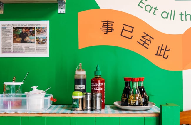 Selection of condiments along a shelf in Penang Street Food.