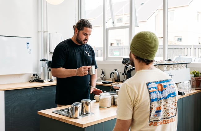 A staff member serving a customer inside a cafe.