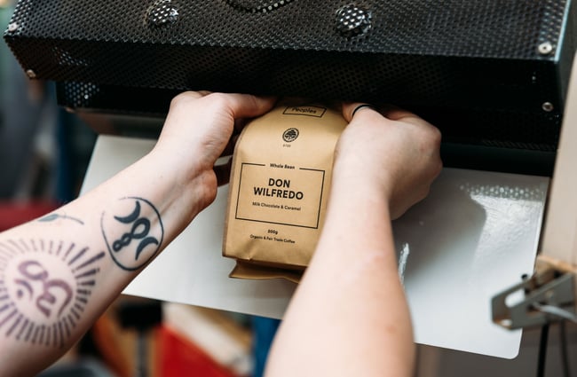 A close up of a paper bag of coffee beans.