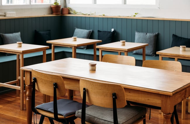 Empty tables and chairs inside a cafe.