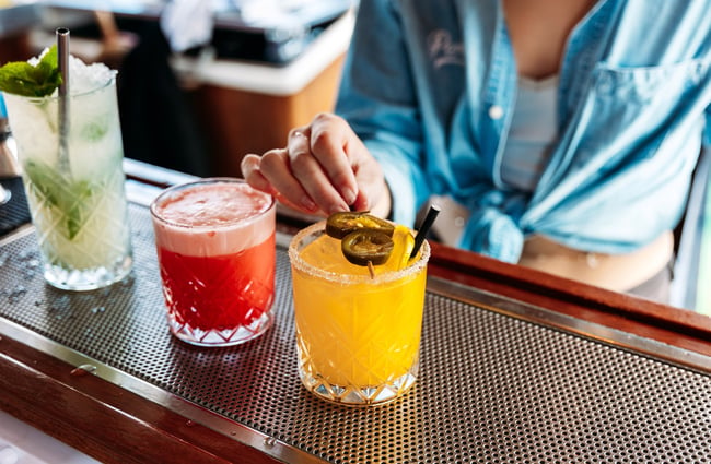 Coloured cocktails on a counter.