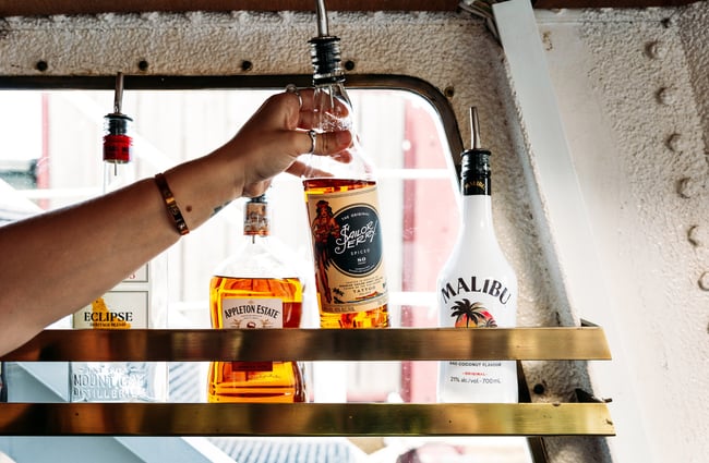 A hand holding a bottle of liquor.
