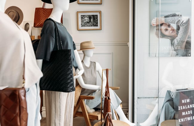 Mannequins in loose clothing wearing wide-brimmed hats in the front window of Perriam.