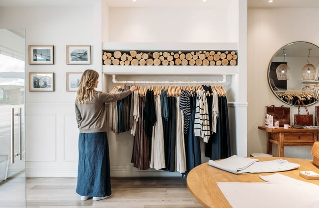 A woman browses a rack of clothes inside Perriam.