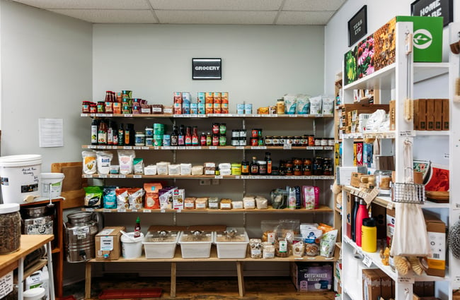 Back shelf in the shop filled with rows of shelves with products on them at Petal Bee Grocers.