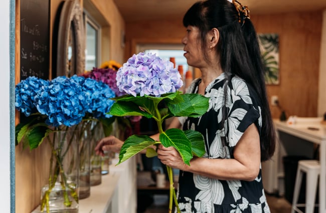 Owner and florist Chico assembling a bouquet at Petals.