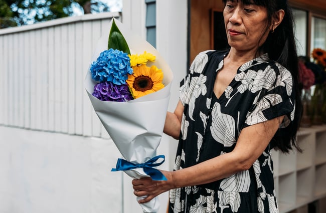 Chico holding a flower arrangement outside Petals.
