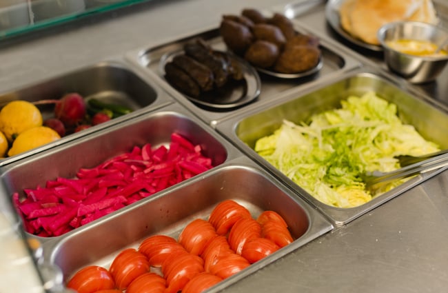Salad ingredients laid out in compartments at Phoenician Falafel.